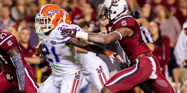 Nov 16, 2013; Columbia, SC, USA; Florida Gators running back Kelvin Taylor (21) breaks the tackle of South Carolina Gamecocks safety Chaz Elder (17) on the way to a touchdown in the second quarter at Williams-Brice Stadium. Mandatory Credit: Jeff Blake-USA TODAY Sports