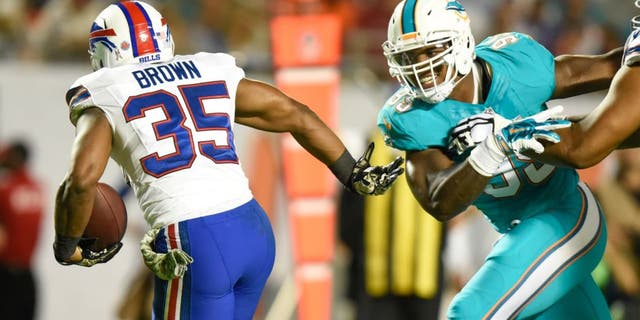 Nov 13, 2014; Miami Gardens, FL, USA; Miami Dolphins long snapper John Denney (92) tries to tackle Buffalo Bills running back Bryce Brown (35) in the first half of the game at Sun Life Stadium. Mandatory Credit: Brad Barr-USA TODAY Sports