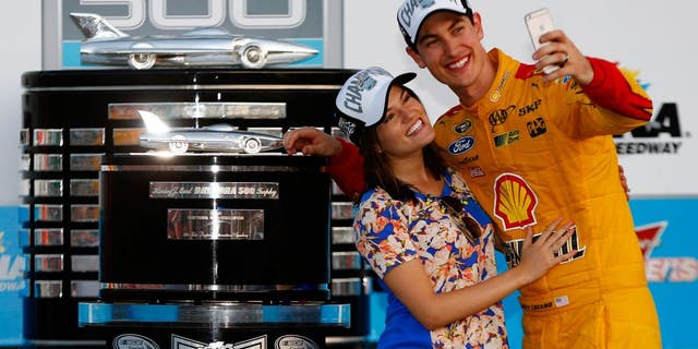 DAYTONA BEACH, FL - FEBRUARY 22: Joey Logano, driver of the #22 Shell Pennzoil Ford, and wife Brittany take a selfie in Victory Lane with The Harley J. Earl Trophy after winning the NASCAR Sprint Cup Series 57th Annual Daytona 500 at Daytona International Speedway on February 22, 2015 in Daytona Beach, Florida. (Photo by Jerry Markland/Getty Images)