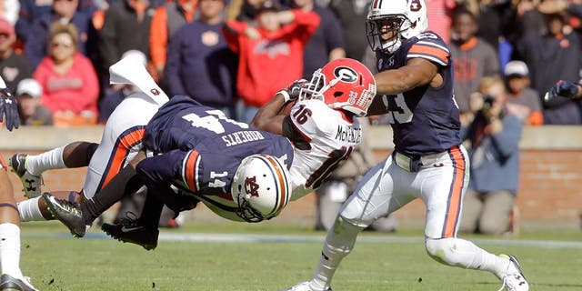 Nov 14, 2015; Auburn, AL, USA; Georgia Bulldogs receiver Isaiah McKenzie (16) is tackled by Auburn Tigers defensive backs Stephen Roberts (14) and Johnathan Ford (23) during the second quarter at Jordan Hare Stadium. Mandatory Credit: John Reed-USA TODAY Sports