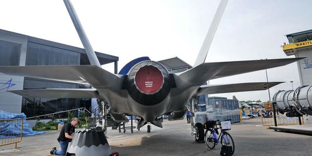 A staff member prepares the replica of Lockheed Martin F-35 fighter jet at the exhibition centre ahead of the Singapore's Airshow on February 9, 2014. Asia's top aerospace and defence show opens on February 11 in Singapore with major global arms makers seeking to cash in on rising military spending as territorial disputes escalate in the region. AFP PHOTO / ROSLAN RAHMAN (Photo credit should read ROSLAN RAHMAN/AFP/Getty Images)