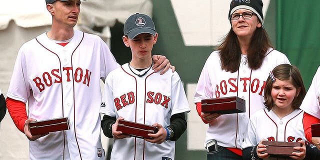 BOSTON - APRIL 4: The Boston Red Sox 2013 World Series team received their championship rings during a pre-game ceremony before their home opener at Fenway Park against the Milwaukee Brewers on Friday, April 4, 2014. Family members of Boston Marathon bombing victim Martin Richard, sister Jane Richard at right, carried the rings onto the field along with others who were affected by the tragedy. (Photo by Jim Davis/The Boston Globe via Getty Images)