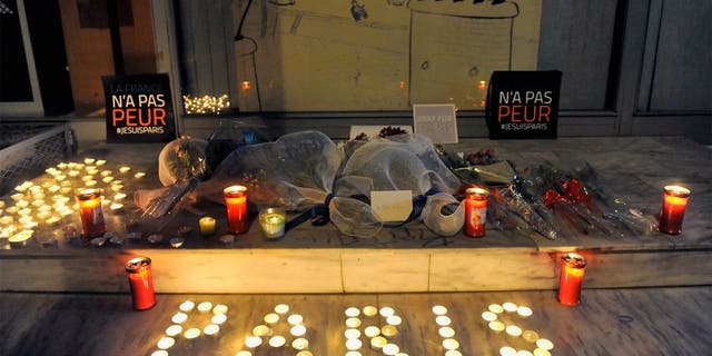 Flowers and candles reading "Paris" are pictured outside the French consulate in Thessaloniki on November 14, 2015, a day after deadly attacks in Paris. Islamic State jihadists claimed a series of coordinated attacks by gunmen and suicide bombers in Paris that killed at least 128 people in scenes of carnage at a concert hall, restaurants and the national stadium. The placards read "France is not afraid". AFP PHOTO / Sakis Mitrolidis (Photo credit should read SAKIS MITROLIDIS/AFP/Getty Images)