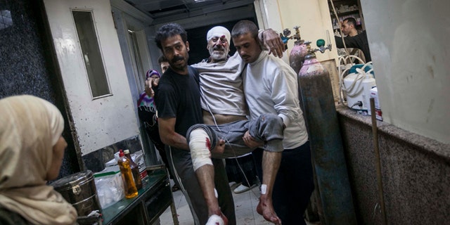 Nov. 13, 2012: A Syrian man is carried in the arms of his relatives at a hospital after he was injured by a mortar shell explosion in the Bab Al-Nayrab neighborhood of Aleppo, Syria.