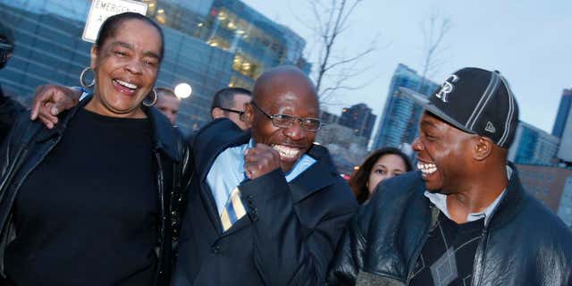 FILE - In this Dec. 22, 2015, file photo, Clarence Moses-EL, center, flanked by his wife Stephanie Burke, left, and an unidentified man jokes after his release from the Denver County jail in Denver