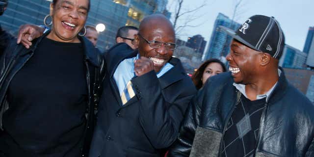 FILE - In this Dec. 22, 2015, file photo, Clarence Moses-EL, center, flanked by his wife Stephanie Burke, left, and an unidentified man jokes after his release from the Denver County jail in Denver