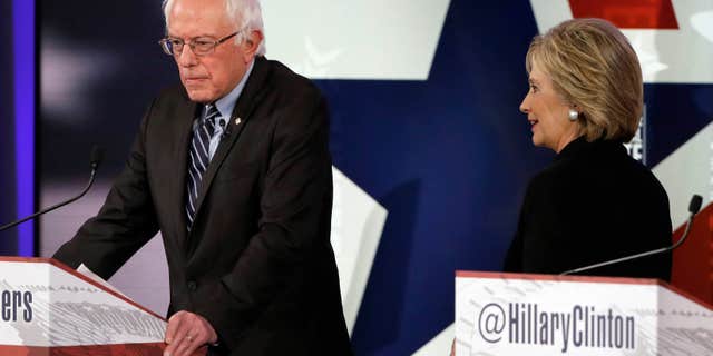 Nov. 14, 2015: Hillary Rodham Clinton, right, walks by Bernie Sanders during a commercial break at a Democratic presidential primary debate in Des Moines, Iowa.