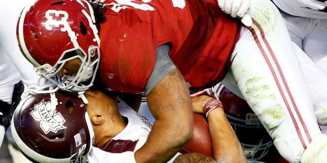 Dak Prescott #15 of the Mississippi State Bulldogs loses his helmet as he is tackled by Trey DePriest #33 of the Alabama Crimson Tide at Bryant-Denny Stadium on November 15, 2014 in Tuscaloosa, Alabama. (Photo by Kevin C. Cox/Getty Images)