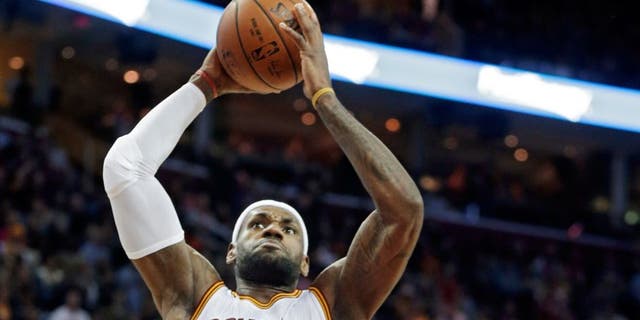 Cleveland Cavaliers' LeBron James (23) goes in for a dunk on Atlanta Hawks' Jeff Teague in the first quarter of an NBA basketball game Saturday, Nov. 15, 2014, in Cleveland. (AP Photo/Mark Duncan)