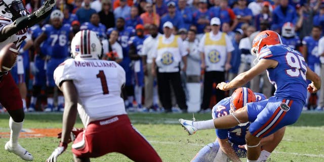 South Carolina safety Brison Williams, far left, blocks a field goal attempt by Florida place kicker Francisco Velez (95) during the second half of an NCAA college football game in Gainesville, Fla., Saturday, Nov. 15, 2014. South Carolina won in overtime 23-20. (AP Photo/John Raoux)