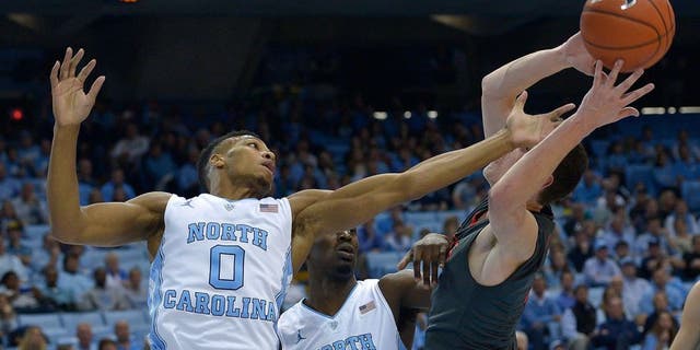 CHAPEL HILL, NC - NOVEMBER 15: Nate Britt #0 and Theo Pinson #1 of the North Carolina Tar Heels battle Matija Milin #34 of the Fairfield Stags during the first half of their game at the Dean Smith Center on November 15, 2015 in Chapel Hill, North Carolina. (Photo by Grant Halverson/Getty Images)