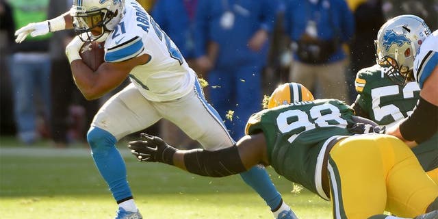 Nov 15, 2015; Green Bay, WI, USA; Detroit Lions running back Ameer Abdullah (21) tries to avoid a tackle by Green Bay Packers defensive tackle Letroy Guion (98) in the second quarter at Lambeau Field. Mandatory Credit: Benny Sieu-USA TODAY Sports
