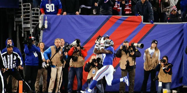 Fans watch as New York Giants wide receiver Dwayne Harris (17) waits for the ball on a touchdown reception during the first half of an NFL football game against the New England Patriots on Sunday, Nov. 15, 2015, in East Rutherford, N.J. (AP Photo/Julio Cortez)