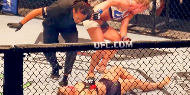 MELBOURNE, AUSTRALIA - NOVEMBER 15: Referee Herb Dean ends the fight as New UFC women's bantamweight champion Holly Holm of the United States starts to celebrate her victory over Ronda Rousey of the United States in their UFC women's bantamweight championship bout during the UFC 193 event at Etihad Stadium on November 15, 2015 in Melbourne, Australia. (Photo by Scott Barbour /Zuffa LLC/Zuffa LLC via Getty Images)