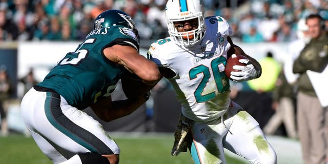 Nov 15, 2015; Philadelphia, PA, USA; Miami Dolphins running back Lamar Miller (26) is pushed out of bounds by Philadelphia Eagles inside linebacker Mychal Kendricks (95) during the first quarter at Lincoln Financial Field. Mandatory Credit: Eric Hartline-USA TODAY Sports