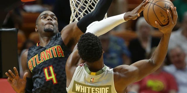 Miami Heat center Hassan Whiteside (21) goes to the basket as Atlanta Hawks forward Paul Millsap (4) defends during the first half of an NBA basketball game, Tuesday, Nov. 15, 2016, in Miami. (AP Photo/Lynne Sladky)