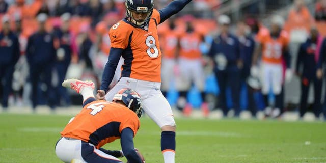 Oct 4, 2015; Denver, CO, USA; Denver Broncos kicker Brandon McManus (8) kicks the go ahead field goal as punter Britton Colquitt (4) holds late in the fourth quarter against the Minnesota Vikings at Sports Authority Field at Mile High. The Broncos defeated the Vikings 23-20. Mandatory Credit: Ron Chenoy-USA TODAY Sports