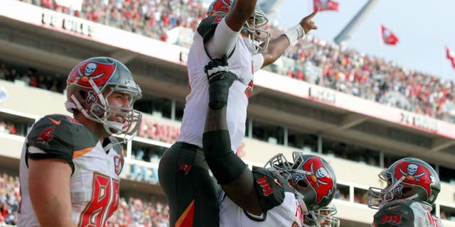 Nov 15, 2015; Tampa, FL, USA; Tampa Bay Buccaneers quarterback Jameis Winston (3) is congratulated by tTampa Bay Buccaneers offensive guard Kevin Pamphile (64) as he ran the ball in for a touchdown during the fourth quarter against the Dallas Cowboys at Raymond James Stadium. Mandatory Credit: Kim Klement-USA TODAY Sports