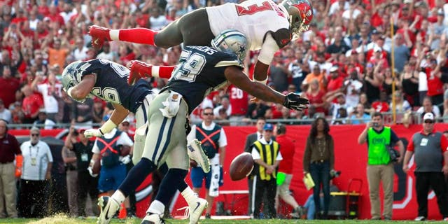 Nov 15, 2015; Tampa, FL, USA; Tampa Bay Buccaneers quarterback Jameis Winston (3) jumps over Dallas Cowboys middle linebacker Anthony Hitchens (59) and fumbles the ball during the second half at Raymond James Stadium. Mandatory Credit: Kim Klement-USA TODAY Sports
