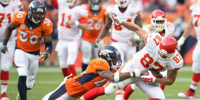 Nov 15, 2015; Denver, CO, USA; Kansas City Chiefs tight end Travis Kelce (87) is brought down by Denver Broncos strong safety T.J. Ward (43) after catching a pass during the first half at Sports Authority Field at Mile High. Mandatory Credit: Chris Humphreys-USA TODAY Sports