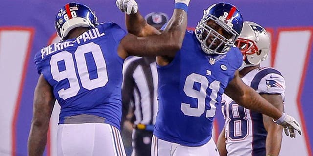Nov 15, 2015; East Rutherford, NJ, USA; New York Giants defensive end Jason Pierre-Paul (90) celebrates with defensive end Robert Ayers (91) during the fourth quarter against the New England Patriots at MetLife Stadium. Jason Pierre-Paul had to put protection on after hurting his hand by deflecting a pass during the first half. New England Patriots defeat the New York Giants 27-26. Mandatory Credit: Jim O'Connor-USA TODAY Sports