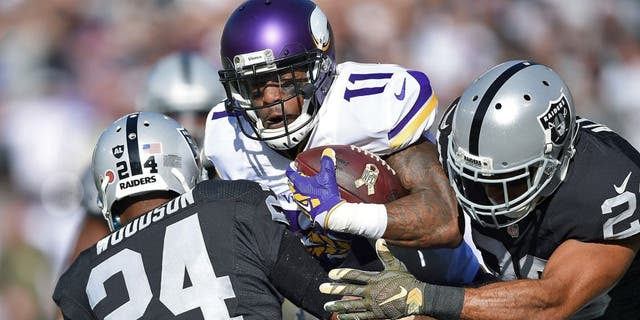 OAKLAND, CA - NOVEMBER 15: Wide receiver Mike Wallace #11 of the Minnesota Vikings is stopped by free safety Charles Woodson #24 of the Oakland Raiders and strong safety Nate Allen #20 of the Oakland Raiders in the first quarter at O.co Coliseum on November 15, 2015 in Oakland, California. (Photo by Thearon W. Henderson/Getty Images)
