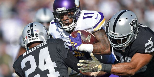 OAKLAND, CA - NOVEMBER 15: Wide receiver Mike Wallace #11 of the Minnesota Vikings is stopped by free safety Charles Woodson #24 of the Oakland Raiders and strong safety Nate Allen #20 of the Oakland Raiders in the first quarter at O.co Coliseum on November 15, 2015 in Oakland, California. (Photo by Thearon W. Henderson/Getty Images)