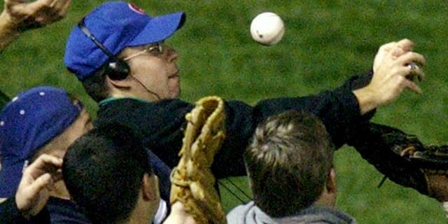 In this Oct 14, 2003 file photo, Steve Bartman catches a ball as Chicago Cubs left fielder Moises Alou's arm is seen reaching into the stands, at right, against the Florida Marlins in the eighth inning during Game 6 of the National League championship series Tuesday, Oct. 14, 2003, at Wrigley Field in Chicago. (AP Photo/Morry Gash) Steve Bartman