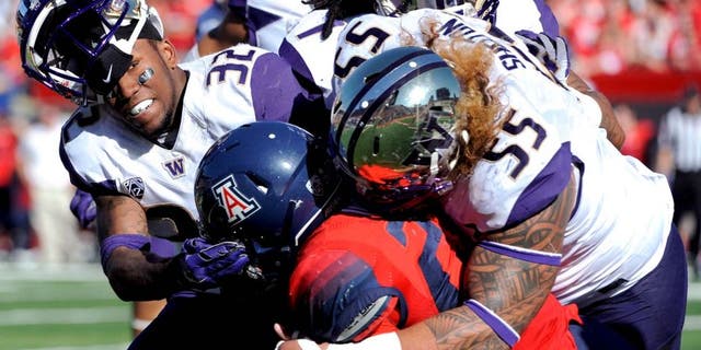 Nov 15, 2014; Tucson, AZ, USA; Washington Huskies defensive back Budda Baker (32) and defensive lineman Danny Shelton (55) tackle Arizona Wildcats running back Nick Wilson (28) during the first half at Arizona Stadium. Mandatory Credit: Casey Sapio-USA TODAY Sports