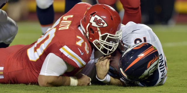 Sep 17, 2015; Kansas City, MO, USA; Denver Broncos quarterback Peyton Manning (18) is sacked by Kansas City Chiefs defensive end Mike DeVito (70) during the first half at Arrowhead Stadium. Mandatory Credit: Denny Medley-USA TODAY Sports