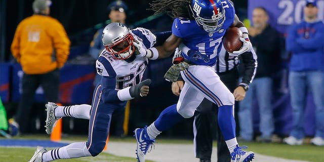 Nov 15, 2015; East Rutherford, NJ, USA; New York Giants wide receiver Dwayne Harris (17) stiff arms New England Patriots cornerback Justin Coleman (22) after a reception during the second quarter at MetLife Stadium. Mandatory Credit: Jim O'Connor-USA TODAY Sports