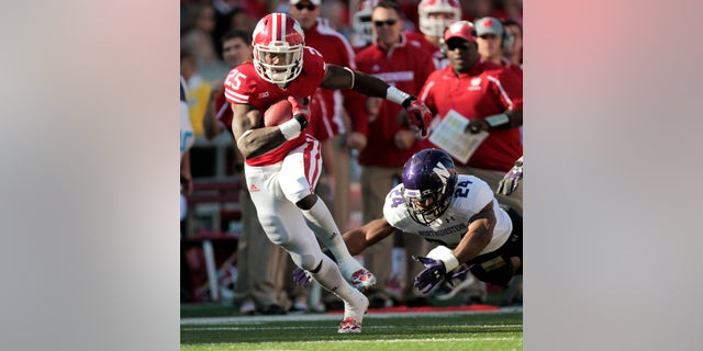 Wisconsin running back Melvin Gordon runs for a first yard against Northwestern safety Ibraheim Campbell during the first half of an NCAA college football game in Madison, Wis., Saturday, Oct. 12, 2013. Wisconsin upset Northwestern 35-6. Gordon had 176 yards. (AP Photo/Andy Manis)