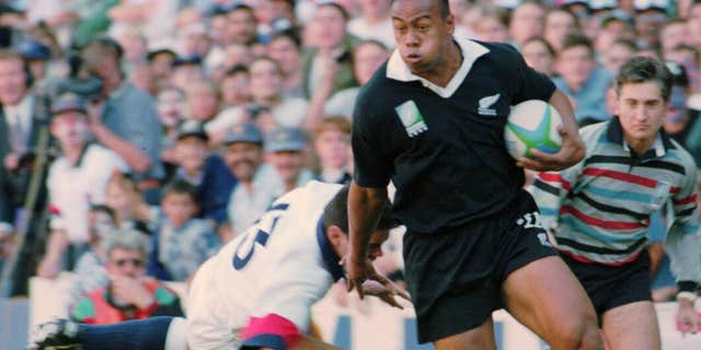 In this June 18, 1995 file photo, New Zealand All Blacks winger Jonah Lomu runs around England's Will Carling on his way to score the opening try in the Rugby World Cup semifinal at Newlands in Cape Town, South Africa.