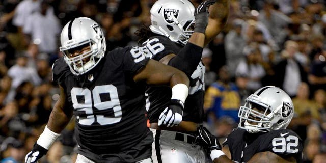 August 14, 2015; Oakland, CA, USA; Oakland Raiders defensive tackle Leon Orr (99), defensive end Denico Autry (96), and defensive tackle Stacy McGee (92) celebrate during the fourth quarter in a preseason NFL football game against the St. Louis Rams at O.co Coliseum. The Raiders defeated the Rams 18-3. Mandatory Credit: Kyle Terada-USA TODAY Sports