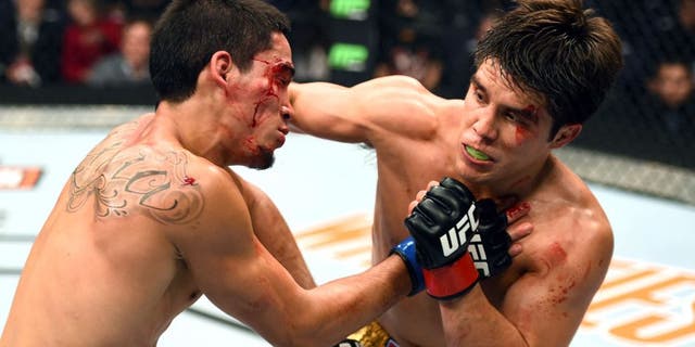 PHOENIX, AZ - DECEMBER 13: (R-L) Henry Cejudo punches Dustin Kimura in their bantamweight fight during the UFC Fight Night event at the U.S. Airways Center on December 13, 2014 in Phoenix, Arizona. (Photo by Josh Hedges/Zuffa LLC/Zuffa LLC via Getty Images)