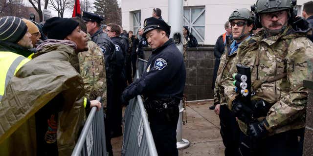 Nov. 18, 2015: A Black Lives Matter supporter, left, talks to Minneapolis police guarding the Fourth Precinct entrance in Minneapolis.