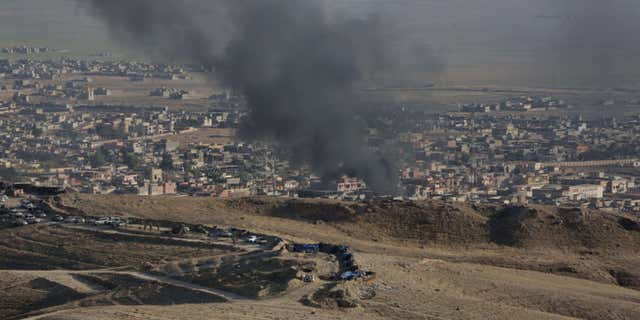Nov. 12, 2015: Smoke rises over Sinjar, northern Iraq from oil fires set by Islamic State militants as Kurdish Iraqi fighters, backed by U.S.-led airstrikes, launch a major assault.