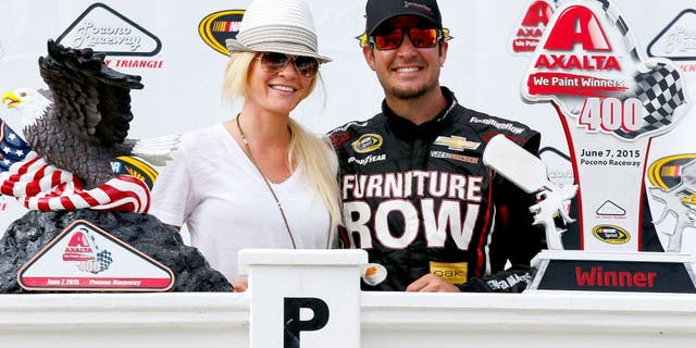 DOVER, DE - MAY 31: Martin Truex Jr., driver of the #78 Furniture Row/Visser Precision Chevrolet, right, and girlfriend Sherry Pollex take part in pre-race ceremonies for the NASCAR Sprint Cup Series FedEx 400 Benefiting Autism Speaks at Dover International Speedway on May 31, 2015 in Dover, Delaware. (Photo by Todd Warshaw/Getty Images)