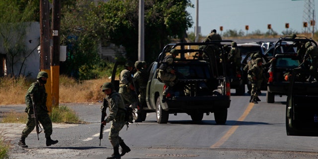 Nov. 19: Soldiers prepare to leave after inspecting a house in Ciudad Mier, Mexico.