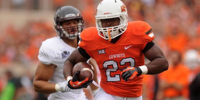 Sep 6, 2014; Stillwater, OK, USA; Oklahoma State Cowboys running back Rennie Childs (23) runs the ball against the Missouri State Bears during the first quarter at Boone Pickens Stadium. Mandatory Credit: Mark D. Smith-USA TODAY Sports