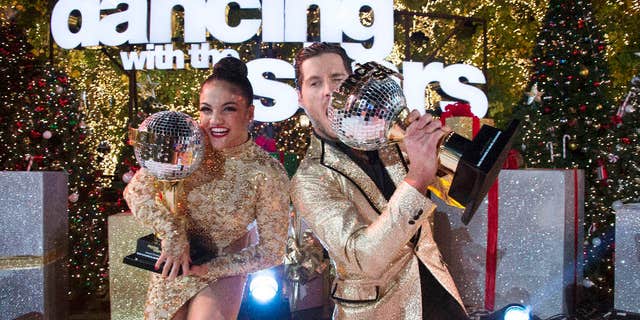 In this Nov. 22, 2016 photo released by ABC, Laurie Hernandez, left, and Val Chmerkovskiy celebrate after winning the 23rd season of the celebrity dance competition series, "Dancing With The Stars," in Los Angeles.