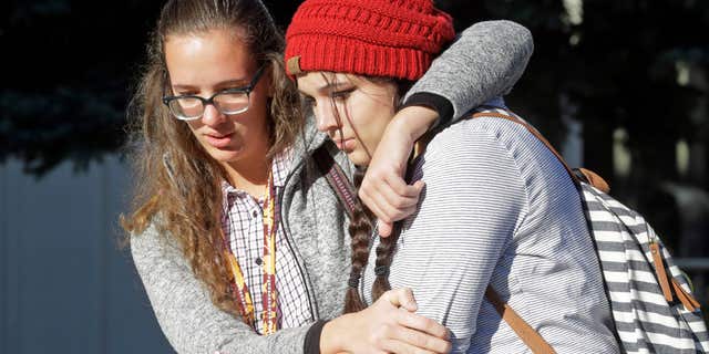 Students Albany Cox, right, and Holly Hilton leave Mountain View High School where several students were stabbed Tuesday, Nov. 15, 2016, in Orem, Utah.