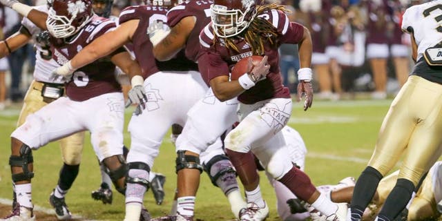 Nov 22, 2014; Starkville, MS, USA; Mississippi State Bulldogs running back Ashton Shumpert (32) carries the ball in for a touchdown during the game against the Vanderbilt Commodores at Davis Wade Stadium. Mandatory Credit: Spruce Derden-USA TODAY Sports