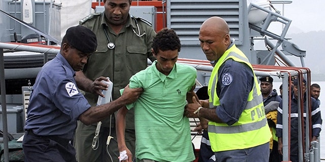 Nov. 26: One of three boys from Tokelau island, center, is helped on his arrival at the Stanley Brown Naval Base in Suva, Fiji.