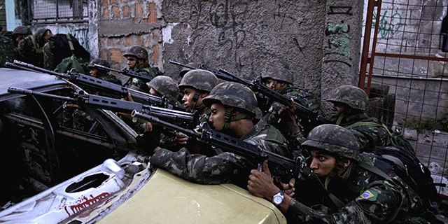 Nov. 27: Soldier aim their weapons during an operation against drug traffickers at the Complexo do Alemao slum in Rio de Janeiro, Brazil.