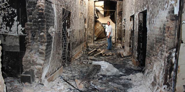 FILE - In this Oct. 16, 2015, file photo, an employee of Doctors Without Borders stands inside the charred remains of their hospital after it was hit by a U.S. airstrike in Kunduz, Afghanistan.