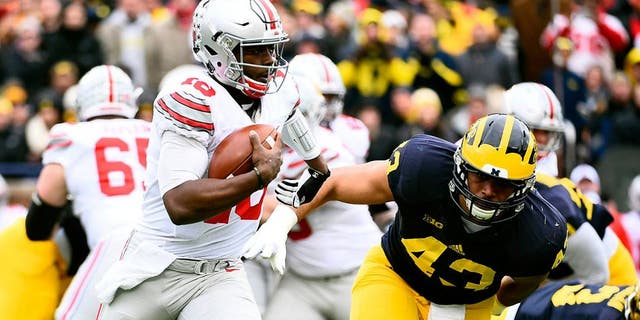 Nov 28, 2015; Ann Arbor, MI, USA; Ohio State Buckeyes quarterback J.T. Barrett (16) runs the ball Michigan Wolverines defensive end Chris Wormley (43) over to defend in the first quarter at Michigan Stadium. Mandatory Credit: Tim Fuller-USA TODAY Sports