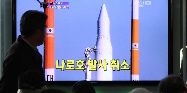 Nov. 29, 2012: People watch a TV broadcasting a report about the cancellation of a launch of the Korea Space Launch Vehicle-1, at Seoul Railway Station in Seoul, South Korea.