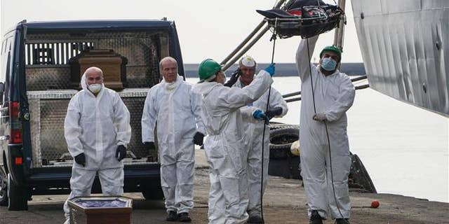 Rescuers recover a dead body from the Spanish ship 'Cantabria' in the harbour of Salerno, Italy, Sunday, Nov. 5 2017. UNHCR spokesman Marco Rotunno said that the 26 dead were involved in a shipwreck two days ago off Libya.
