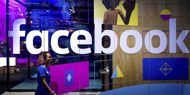 In this Tuesday, April 18, 2017, file photo, a conference worker passes a demo booth at Facebook's annual F8 developer conference, in San Jose, Calif. Facebook Inc. reports earnings Wednesday, Jan. 31, 2018.